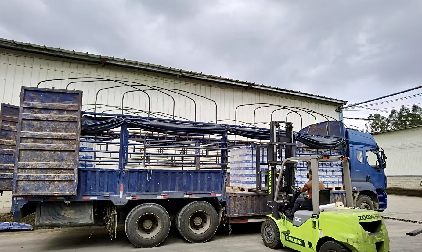 Forklift loading cartons onto a delivery truck